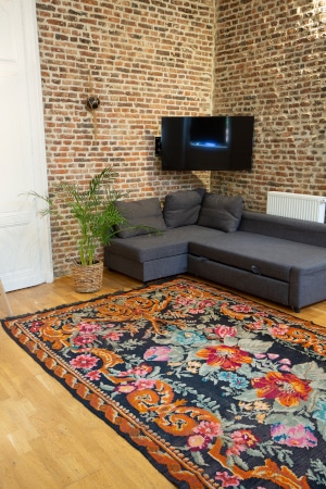 Tapis kilim canapé d'angle gris salon avec mur en brique